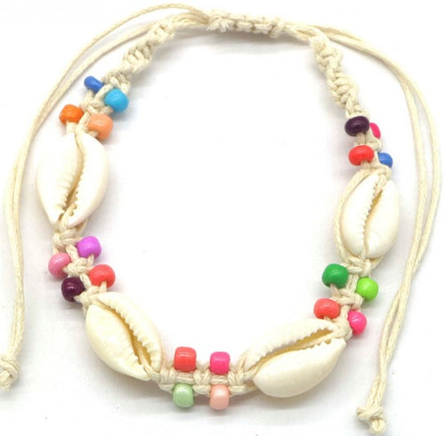 enkelbandje van macrame met gekleurde kraaltjes erin verwerkt. Daarnaast zitten er 4 kauri schelpjes aan.