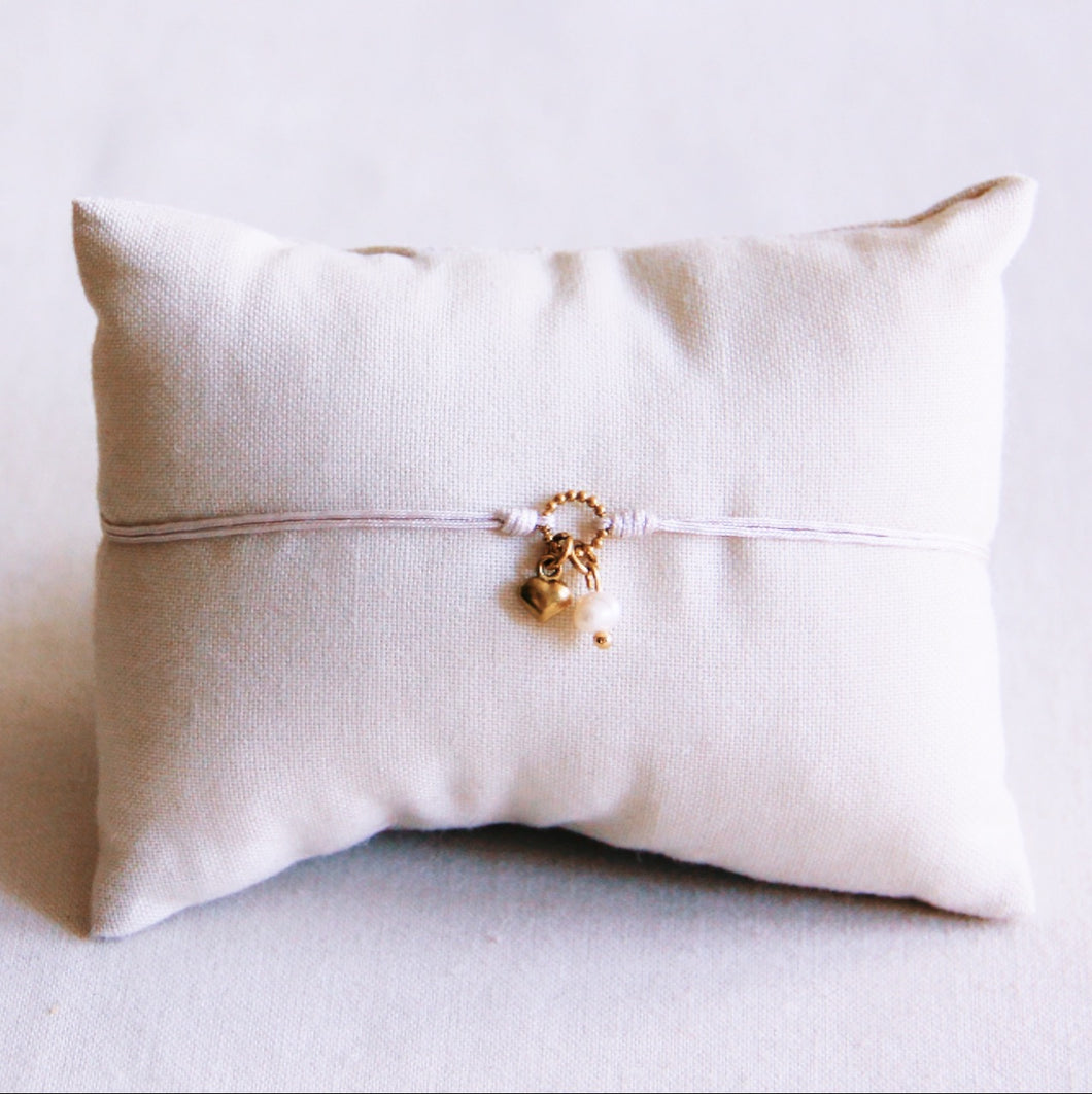 enkelbandje aan een beige satijndraad met goudkleuri hartje en een parel